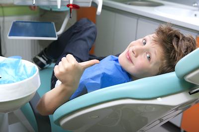 little boy thumbs up in dental chair